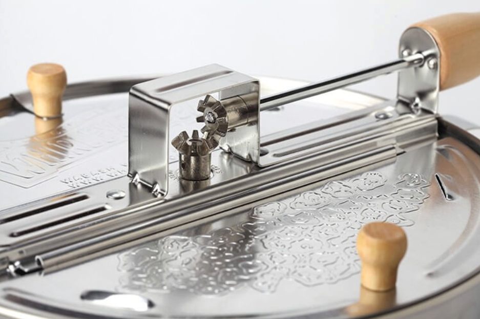 Metal popcorn maker with wooden handles on a white background